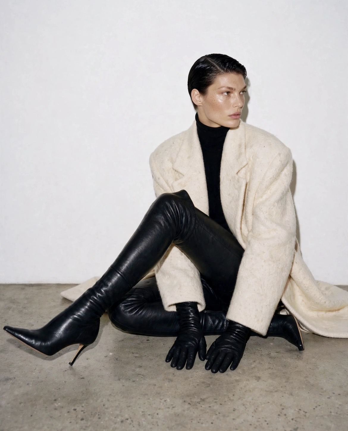 Seated fashion portrait in a cream coat